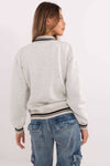 Back view of grey Women's Bomber Jacket showing ribbed hem and relaxed fit, paired with blue cargo jeans for a casual look.