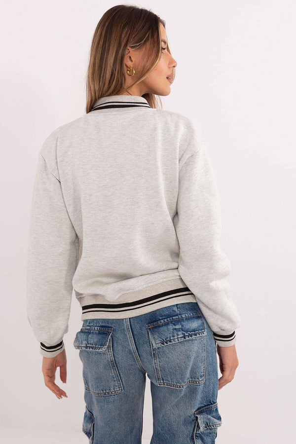 Back view of grey Women's Bomber Jacket showing ribbed hem and relaxed fit, paired with blue cargo jeans for a casual look.